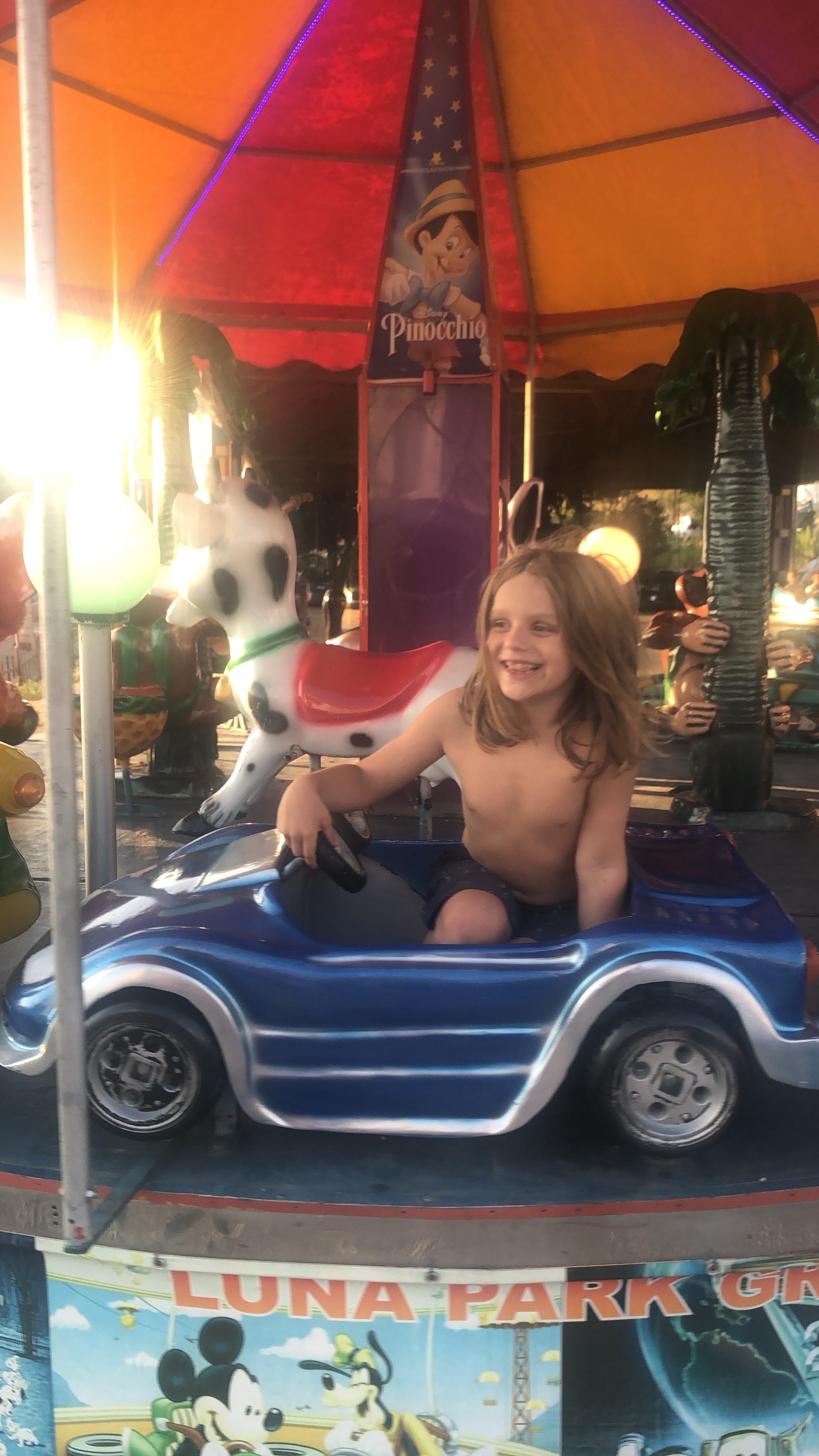 Instagram Shadow Ban - Charlie is on a fairground ride at the beach in shorts and is smiling 