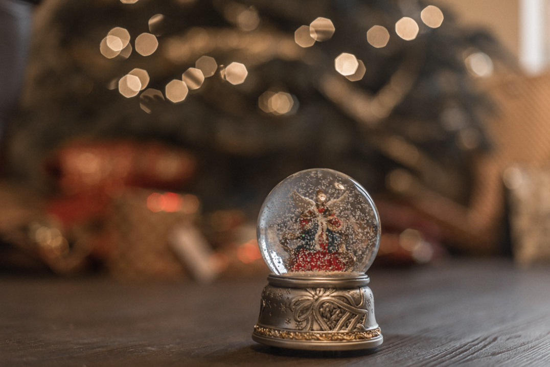 Minding your mental health at Christmas time - A Christmas snow globe in front of the Christmas Tree and Gifts